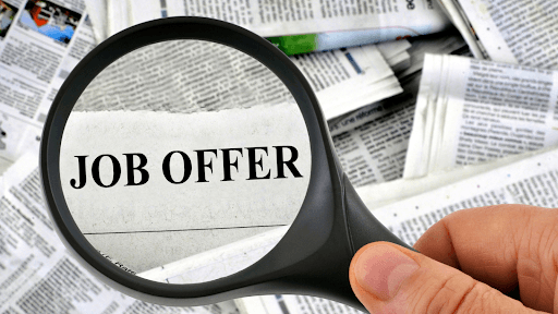 A magnifying glass focusing on the word "JOB OFFER"