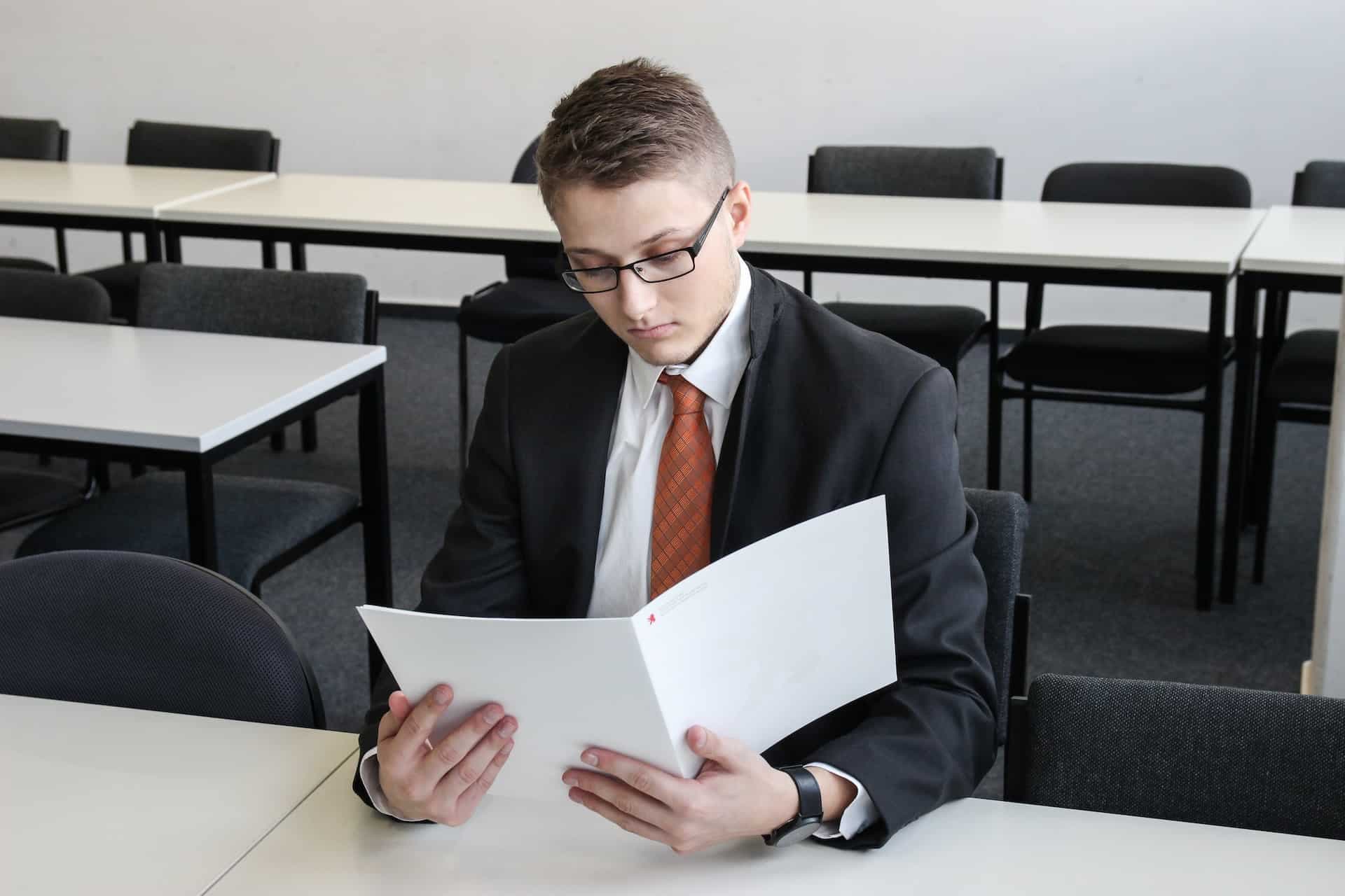A man holding a folder in an empty room.